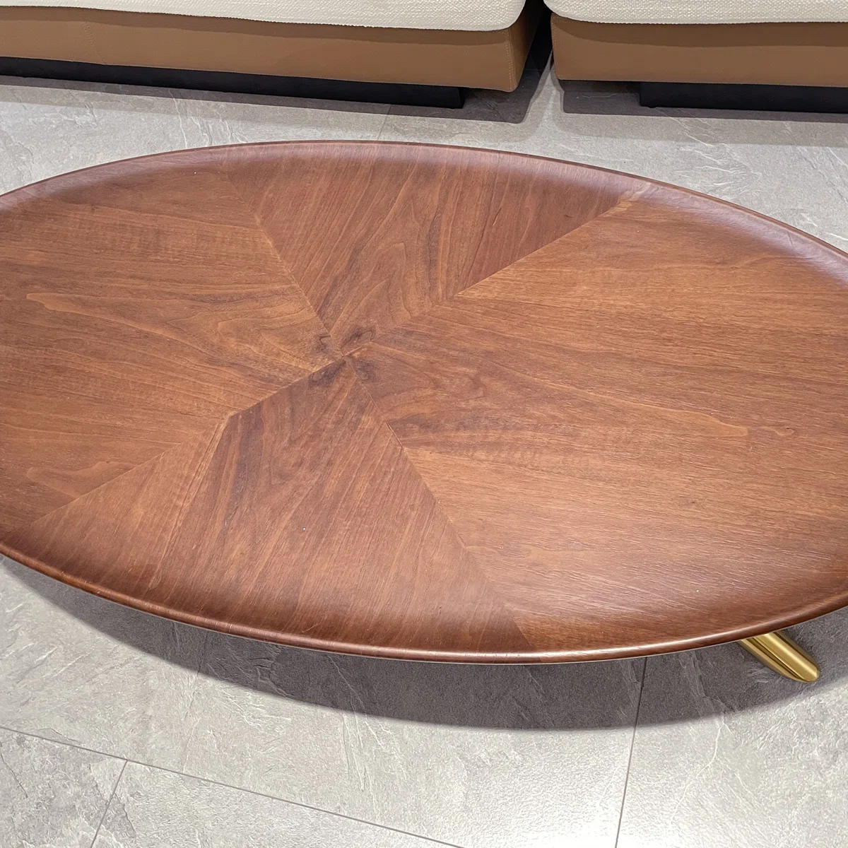 Liora Retro Oval Coffee Table with wood-grain finish and gold stainless-steel legs, 60 cm tall, styled in a modern living room