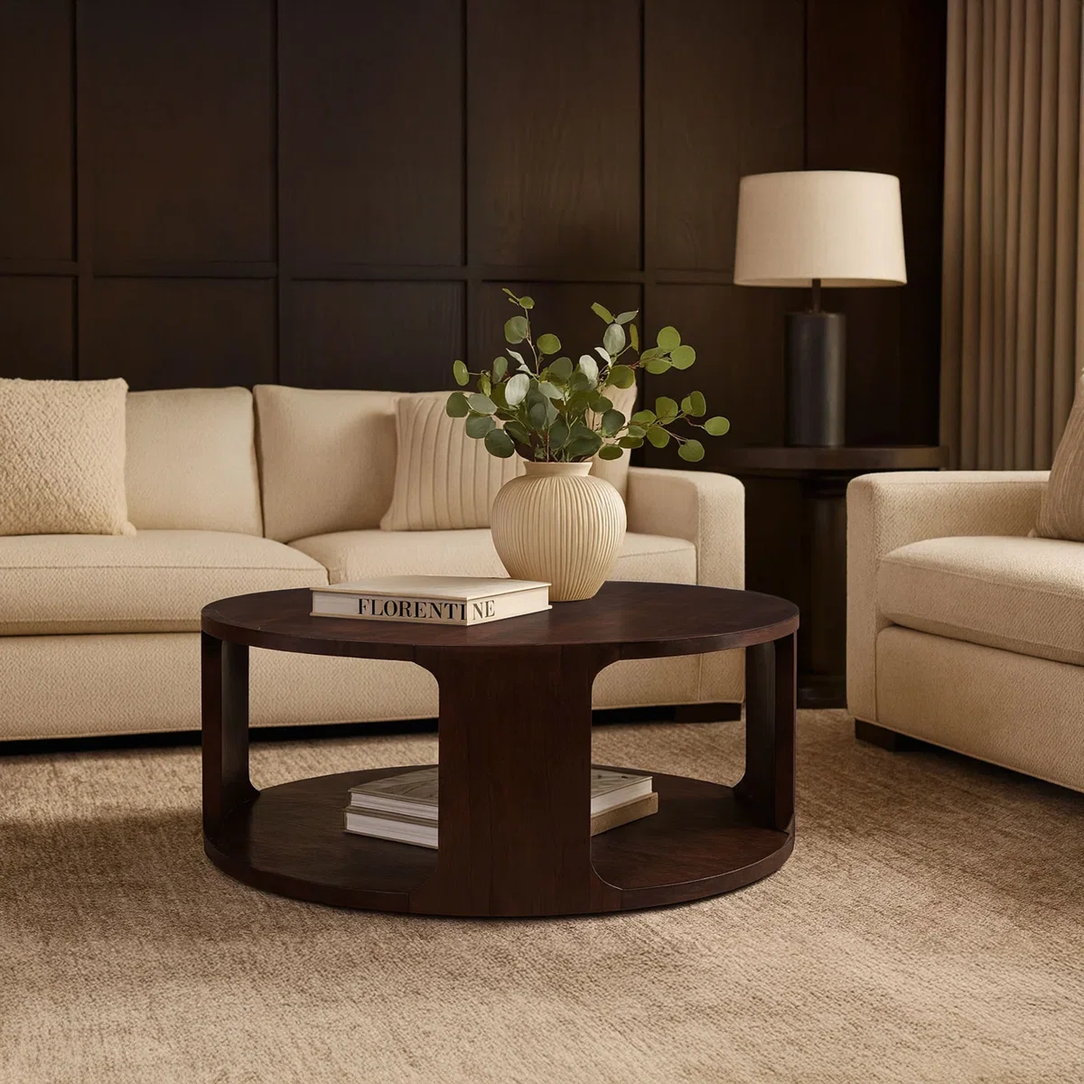 Lyric Round Coffee Table in walnut brown mango wood, 96.5 cm round top with sculptural frame and open lower shelf.