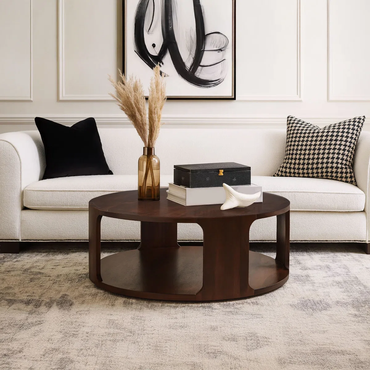 Lyric Round Coffee Table in walnut brown mango wood, 96.5 cm round top with sculptural frame and open lower shelf.