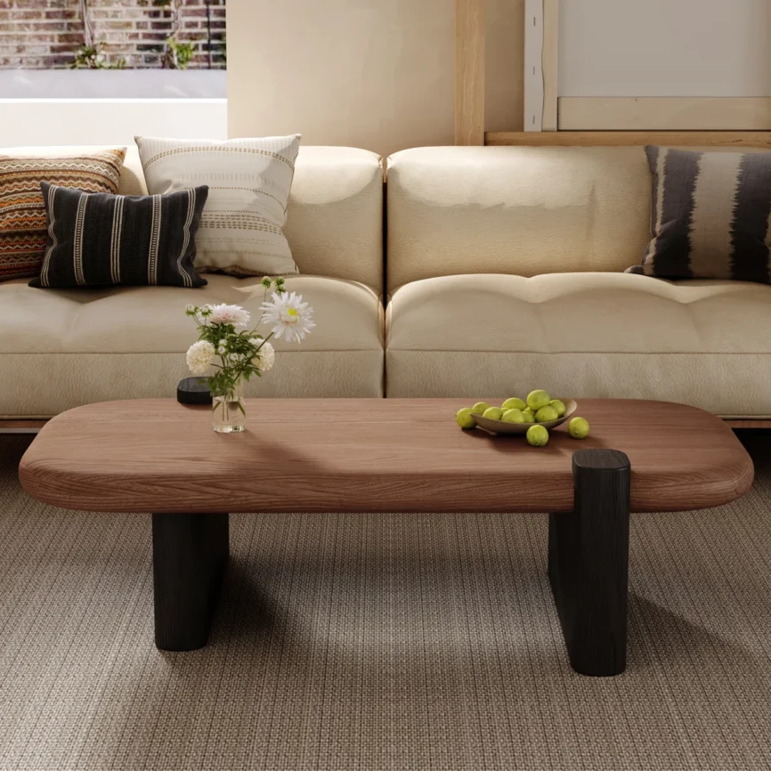 Rectangular walnut coffee table with rounded corners, natural wood grain top, and black sled base, styled as a farmhouse‑inspired living room centerpiece.