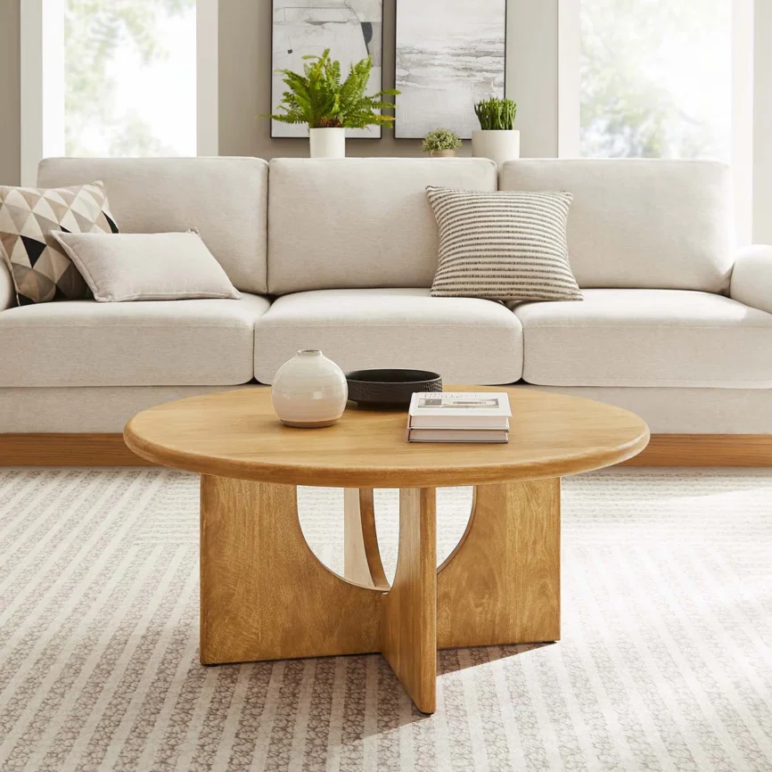 Round solid mango wood coffee table with sculptural pedestal base featuring intersecting arched cutouts